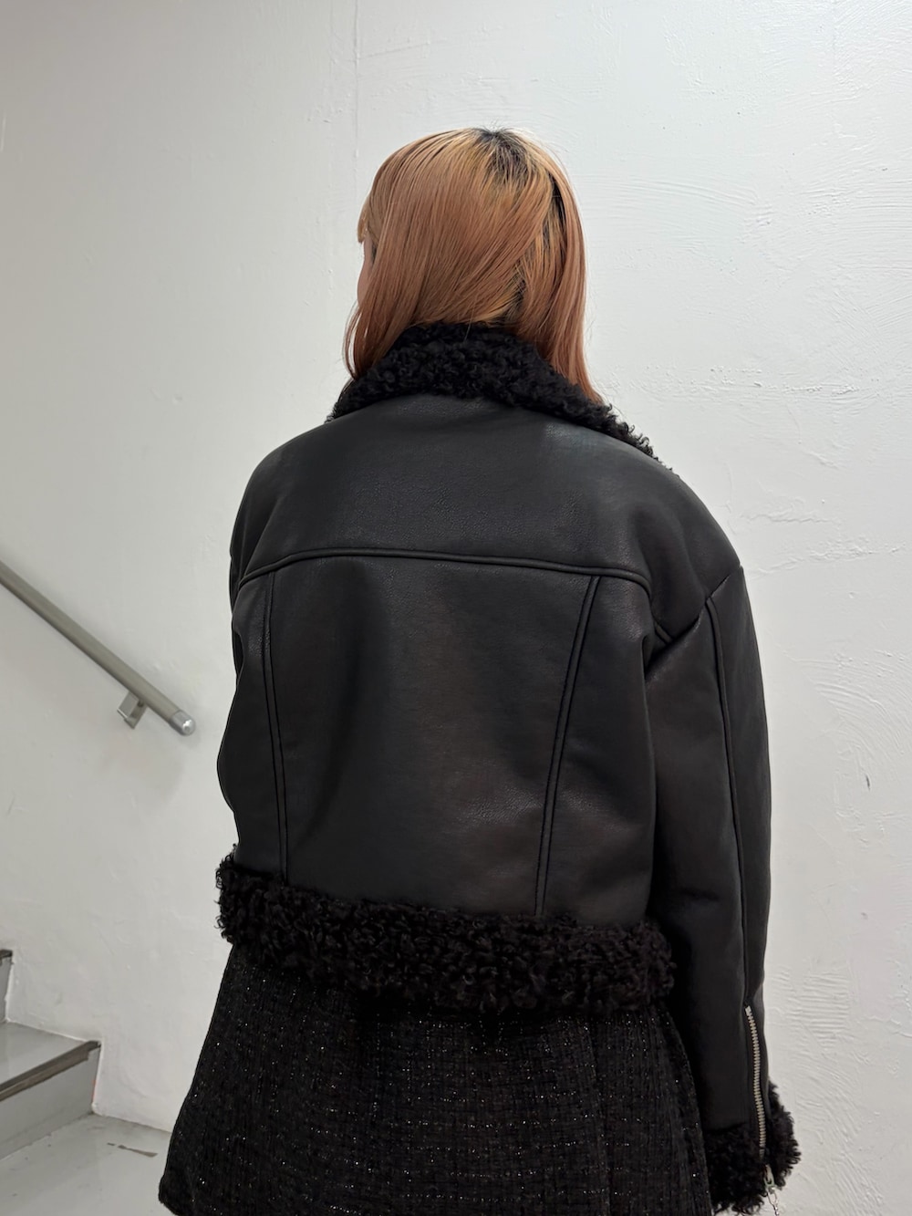 ブラック系のムートンコート、ブラック系のワンピース、レッド系のニット/セーターを着用したレディースの秋コーディネートの6枚目の写真