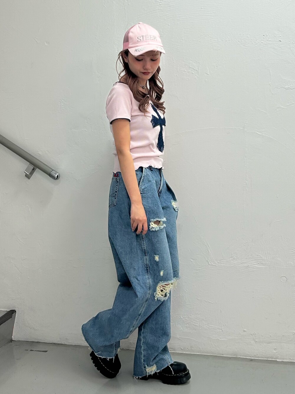 ピンク系のTシャツ/カットソー、ブルー系のデニムパンツ、ピンク系のキャップを着用したレディースの春コーディネートの2枚目の写真