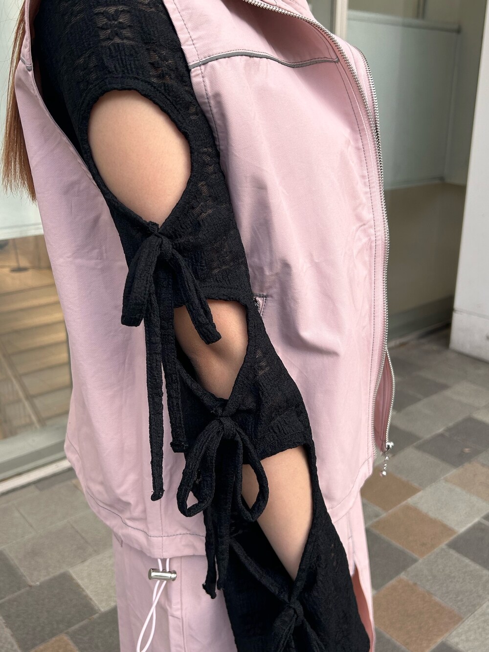 ブラック系のTシャツ/カットソー、ピンク系のベスト、ピンク系のスカートを着用したレディースの春コーディネートの9枚目の写真