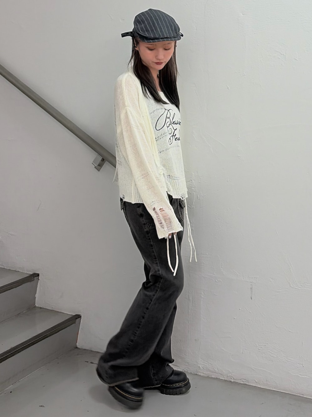 ホワイト系のニット/セーター、ブラック系のデニムパンツ、グレー系のハンチング/ベレー帽を着用したレディースの冬コーディネートの3枚目の写真