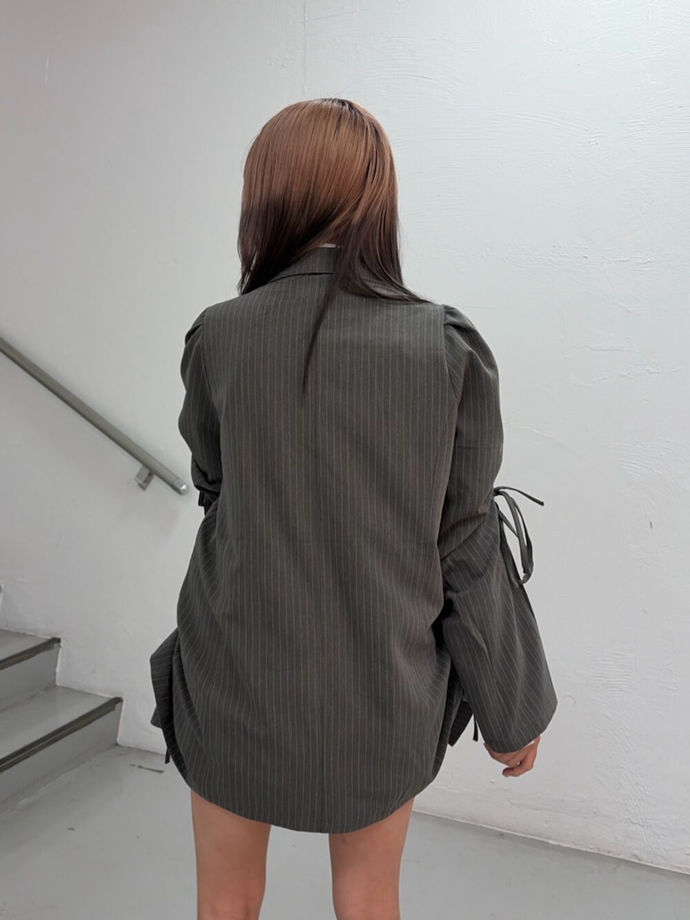 グレー系のテーラードジャケット、グレー系のスカート、ホワイト系のシャツ/ブラウスを着用したレディースの冬コーディネートの7枚目の写真