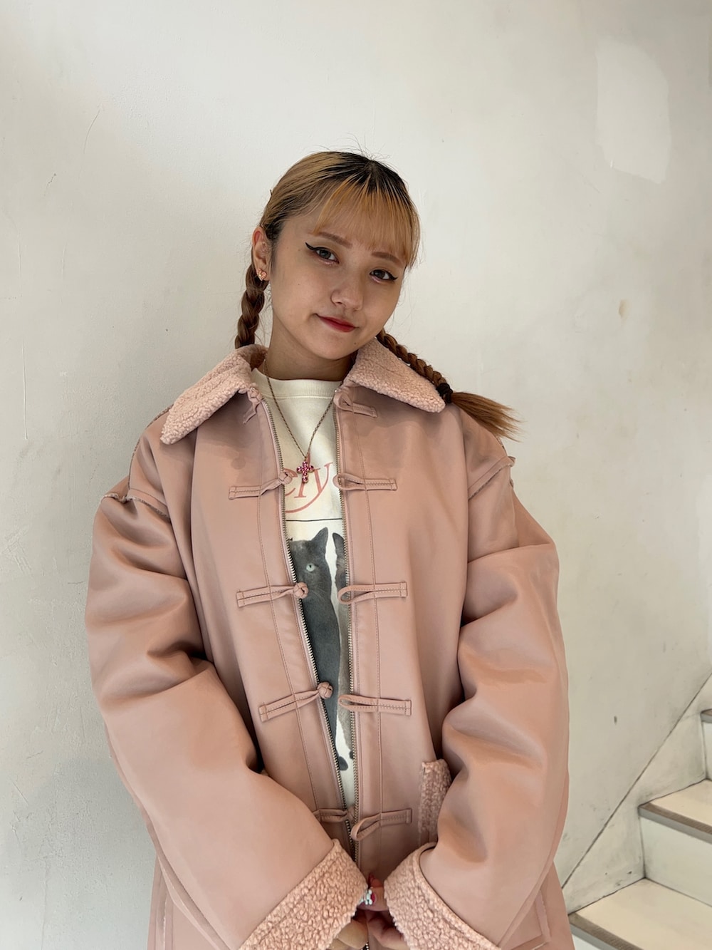 ピンク系のムートンコート、ホワイト系のスウェット、ブラック系のブーツを着用したレディースの秋コーディネートの4枚目の写真