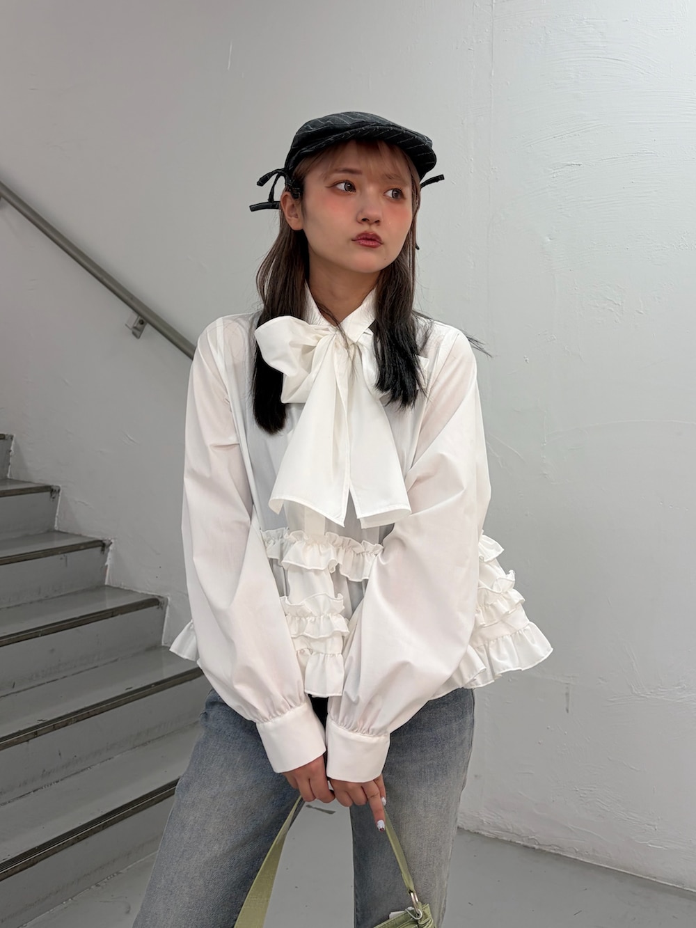 ホワイト系のシャツ/ブラウス、ブルー系のデニムパンツ、グリーン系のハンドバッグを着用したレディースの冬コーディネートの5枚目の写真