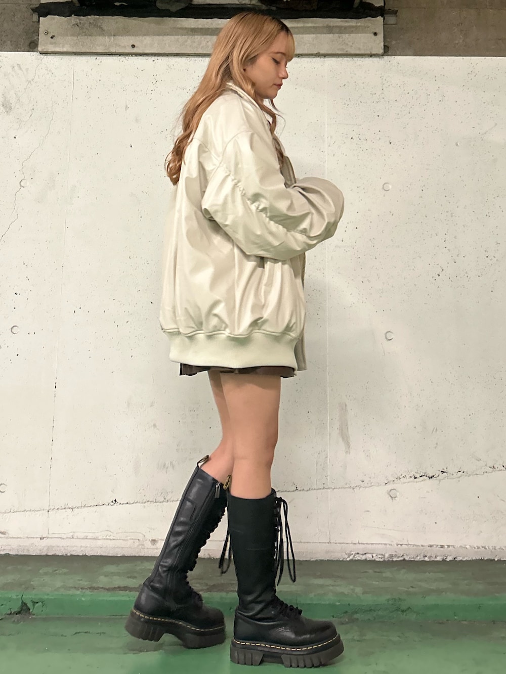 ホワイト系のブルゾン、レッド系のTシャツ/カットソー、ブラウン系のスカートを着用したレディースの秋コーディネートの2枚目の写真