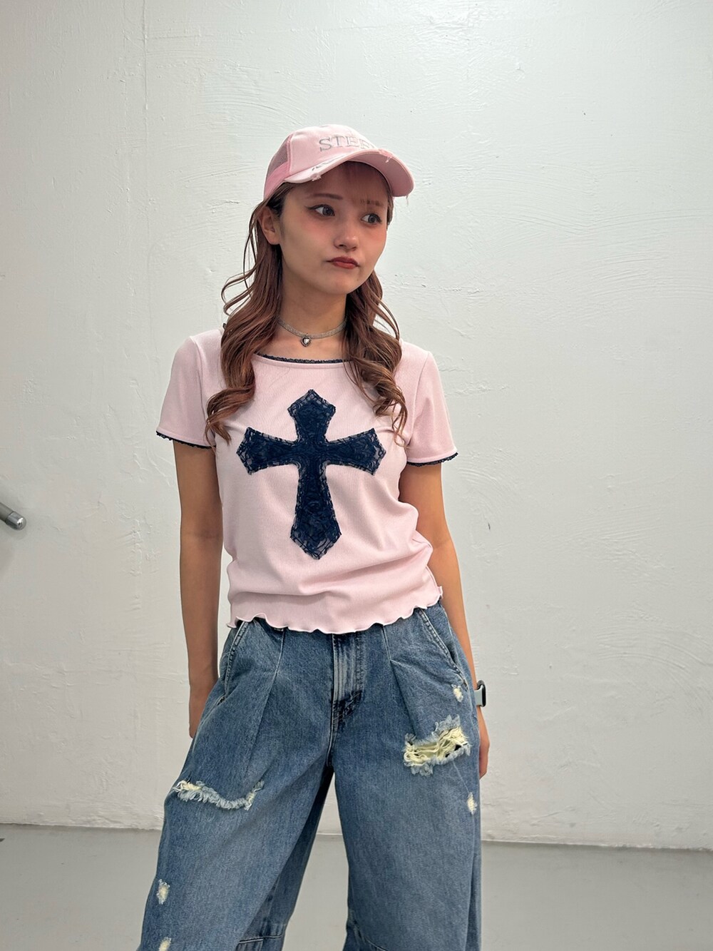 ピンク系のTシャツ/カットソー、ブルー系のデニムパンツ、ピンク系のキャップを着用したレディースの春コーディネートの4枚目の写真