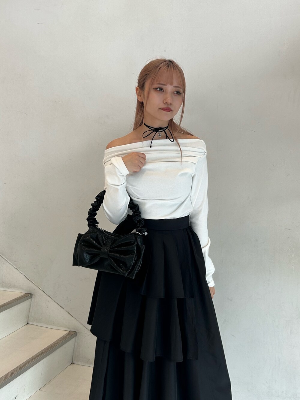 ホワイト系のTシャツ/カットソー、ブラック系のスカート、ブラック系のハンドバッグを着用したレディースの春コーディネートの4枚目の写真