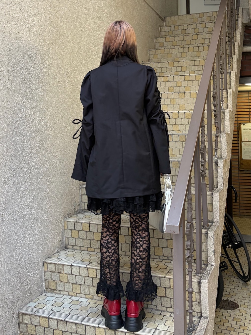 ブラック系のテーラードジャケット、ブラック系のその他パンツ、シルバー系のハンドバッグを着用したレディースの冬コーディネートの3枚目の写真