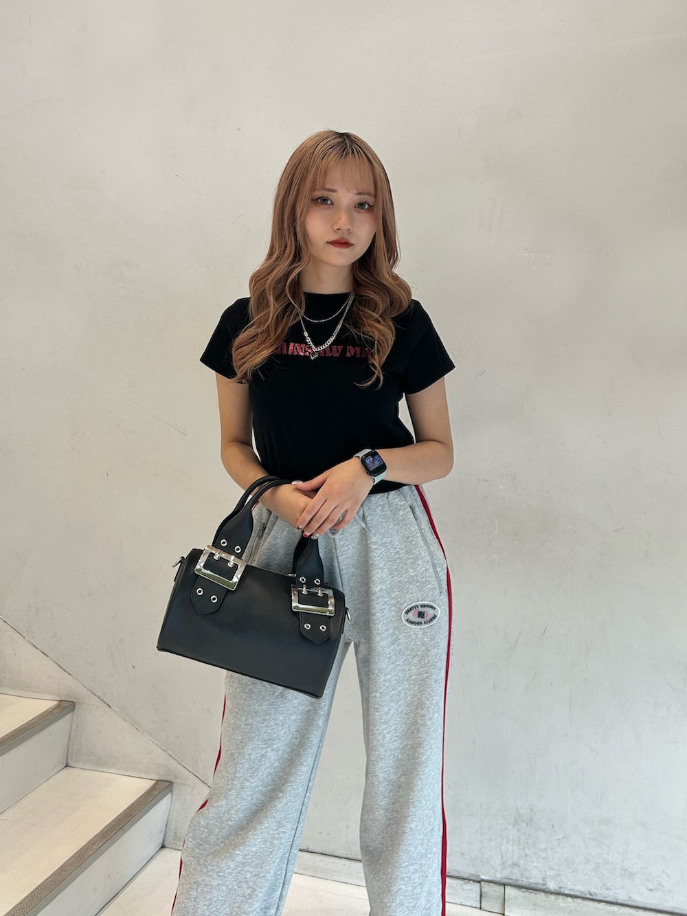 ブラック系のTシャツ/カットソー、グレー系のスウェットパンツ、ブラック系のボストンバッグを着用したレディースの春コーディネートの4枚目の写真