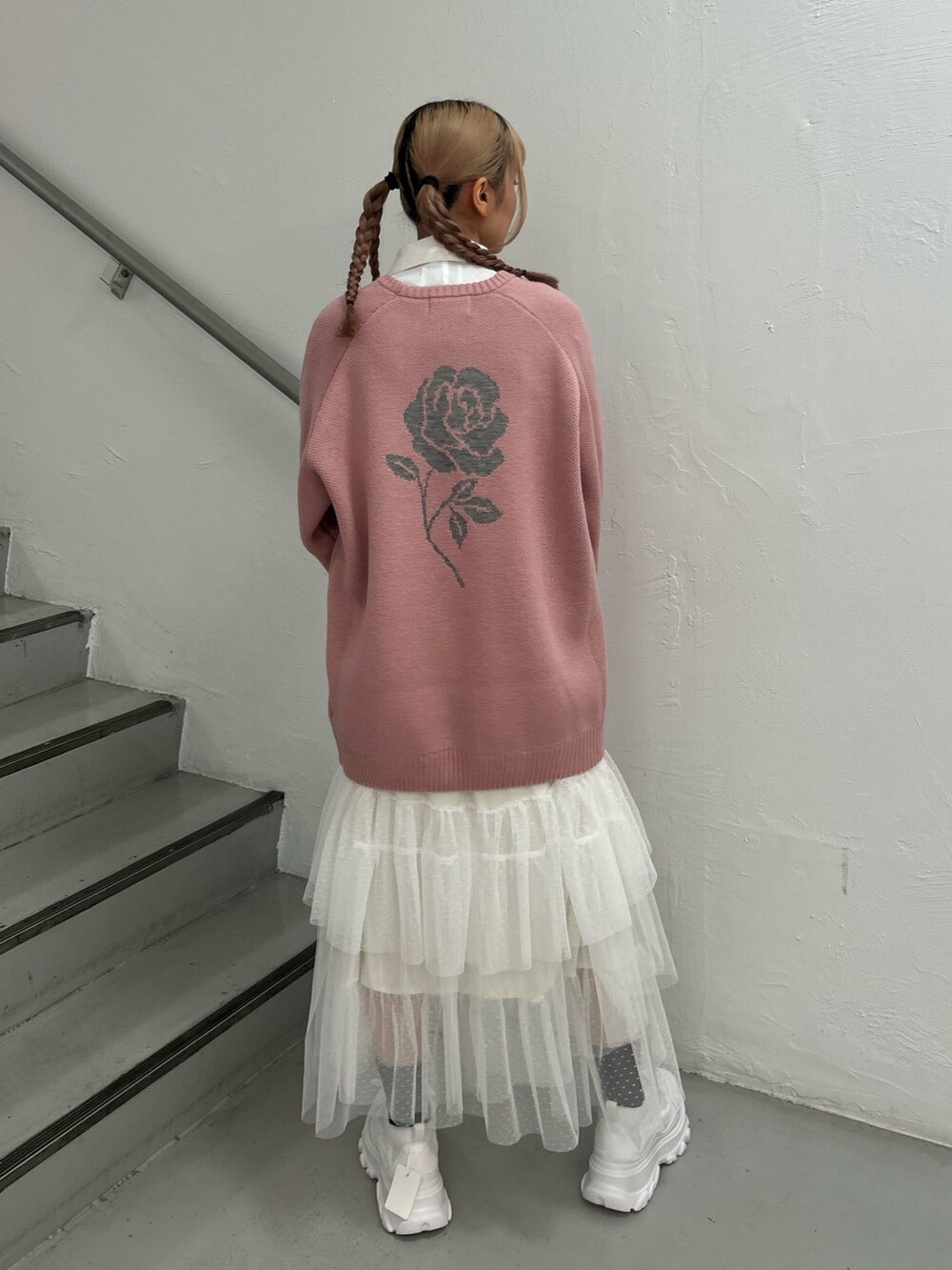 ピンク系のニット/セーター、ホワイト系のシャツ/ブラウス、ホワイト系のスカートを着用したレディースの冬コーディネートの3枚目の写真