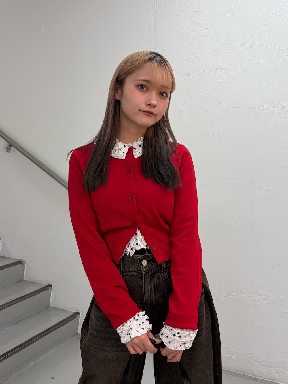 レッド系のカーディガン/ボレロ、ホワイト系のシャツ/ブラウス、ブラック系のデニムパンツを着用したレディースの春コーディネートの5枚目の写真