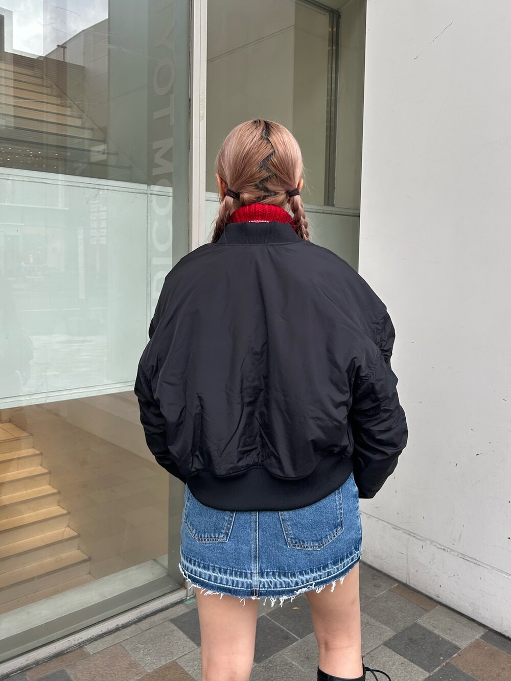 ブルー系のデニムパンツ、ブラック系のMA-1、レッド系のニット/セーターを着用したレディースの秋コーディネートの6枚目の写真