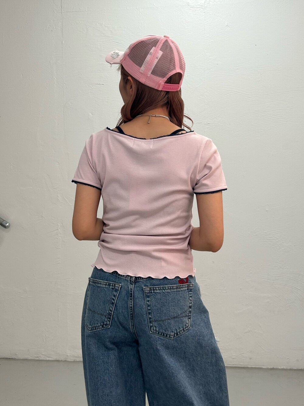 ピンク系のTシャツ/カットソー、ブルー系のデニムパンツ、ピンク系のキャップを着用したレディースの春コーディネートの6枚目の写真