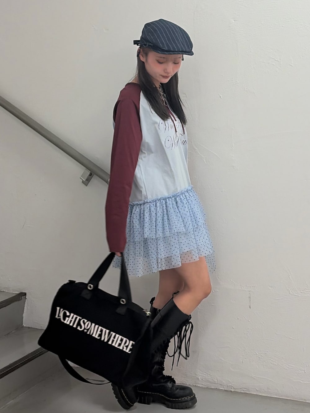 ブルー系のワンピース、ブラック系のボストンバッグ、グレー系のハンチング/ベレー帽を着用したレディースの冬コーディネートの3枚目の写真