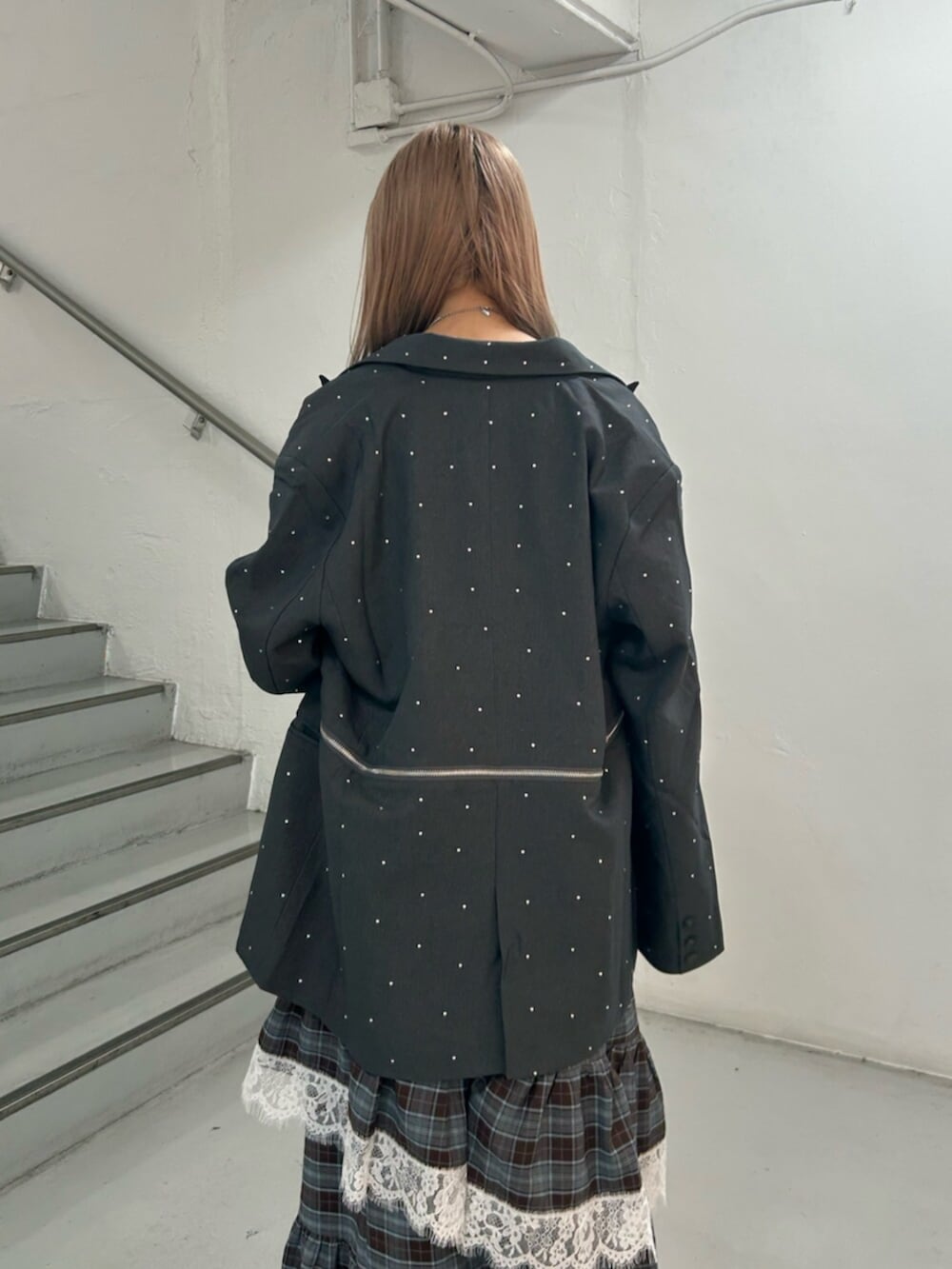 グレー系のテーラードジャケット、ブラック系のスニーカー、ブラウン系のワンピースを着用したレディースの秋コーディネートの6枚目の写真