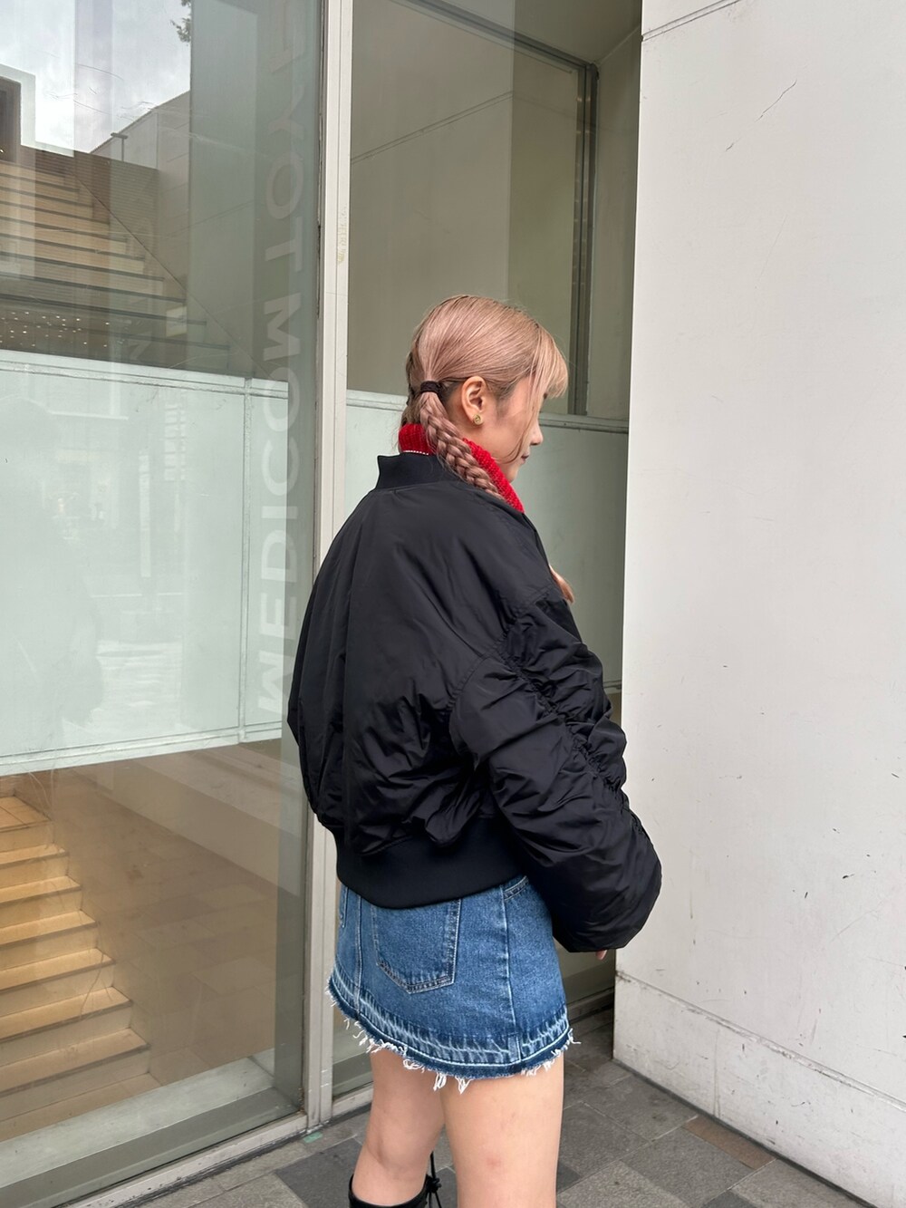 ブルー系のデニムパンツ、ブラック系のMA-1、レッド系のニット/セーターを着用したレディースの秋コーディネートの5枚目の写真