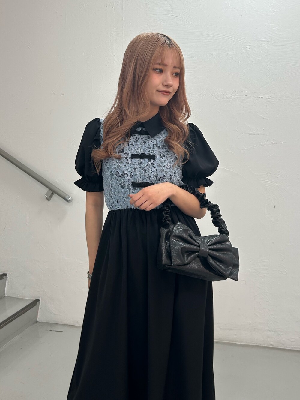 ブラック系のワンピース、ブラック系のハンドバッグ、シルバー系のブレスレットを着用したレディースの春コーディネートの4枚目の写真