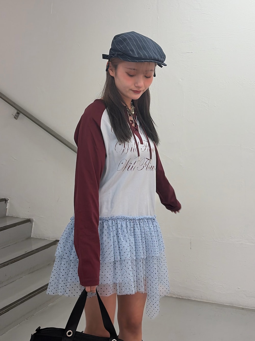 ブルー系のワンピース、ブラック系のボストンバッグ、グレー系のハンチング/ベレー帽を着用したレディースの冬コーディネートの6枚目の写真