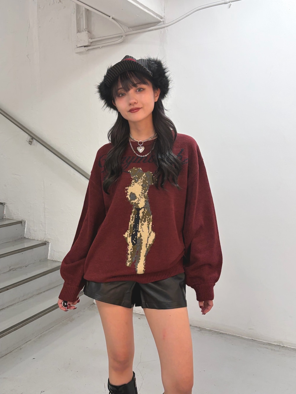 レッド系のニット/セーター、ブラック系のその他パンツ、ブラック系のキャップを着用したレディースの秋コーディネートの5枚目の写真
