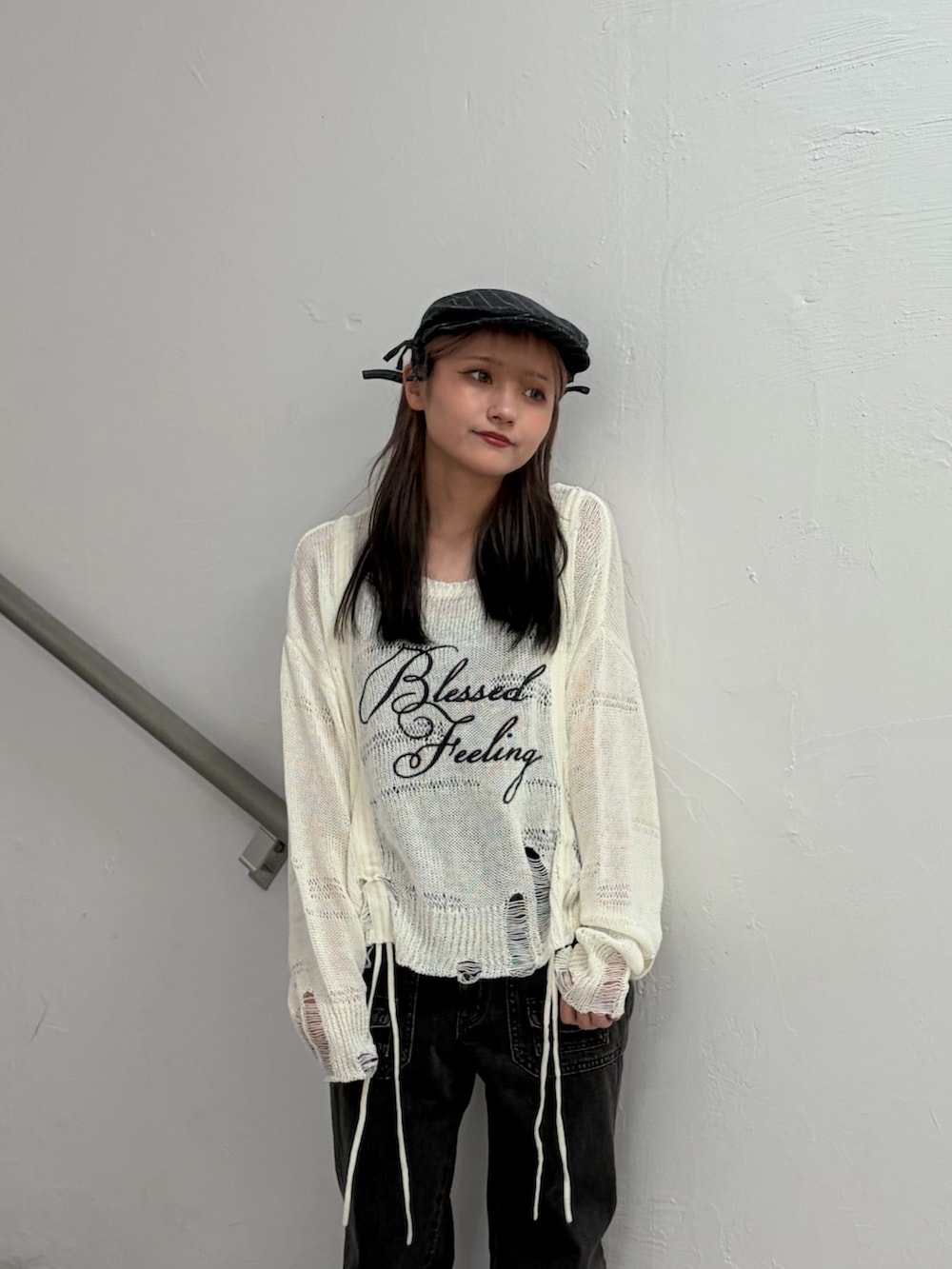 ホワイト系のニット/セーター、ブラック系のデニムパンツ、グレー系のハンチング/ベレー帽を着用したレディースの冬コーディネートの5枚目の写真