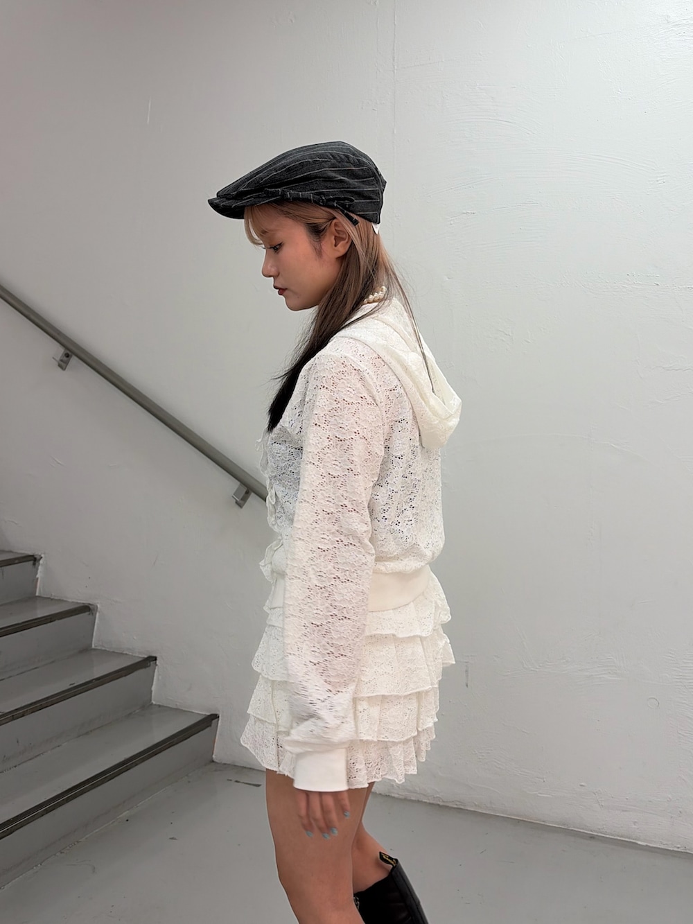 ホワイト系のパーカー、ホワイト系のスカート、グレー系のハンチング/ベレー帽を着用したレディースの春コーディネートの6枚目の写真