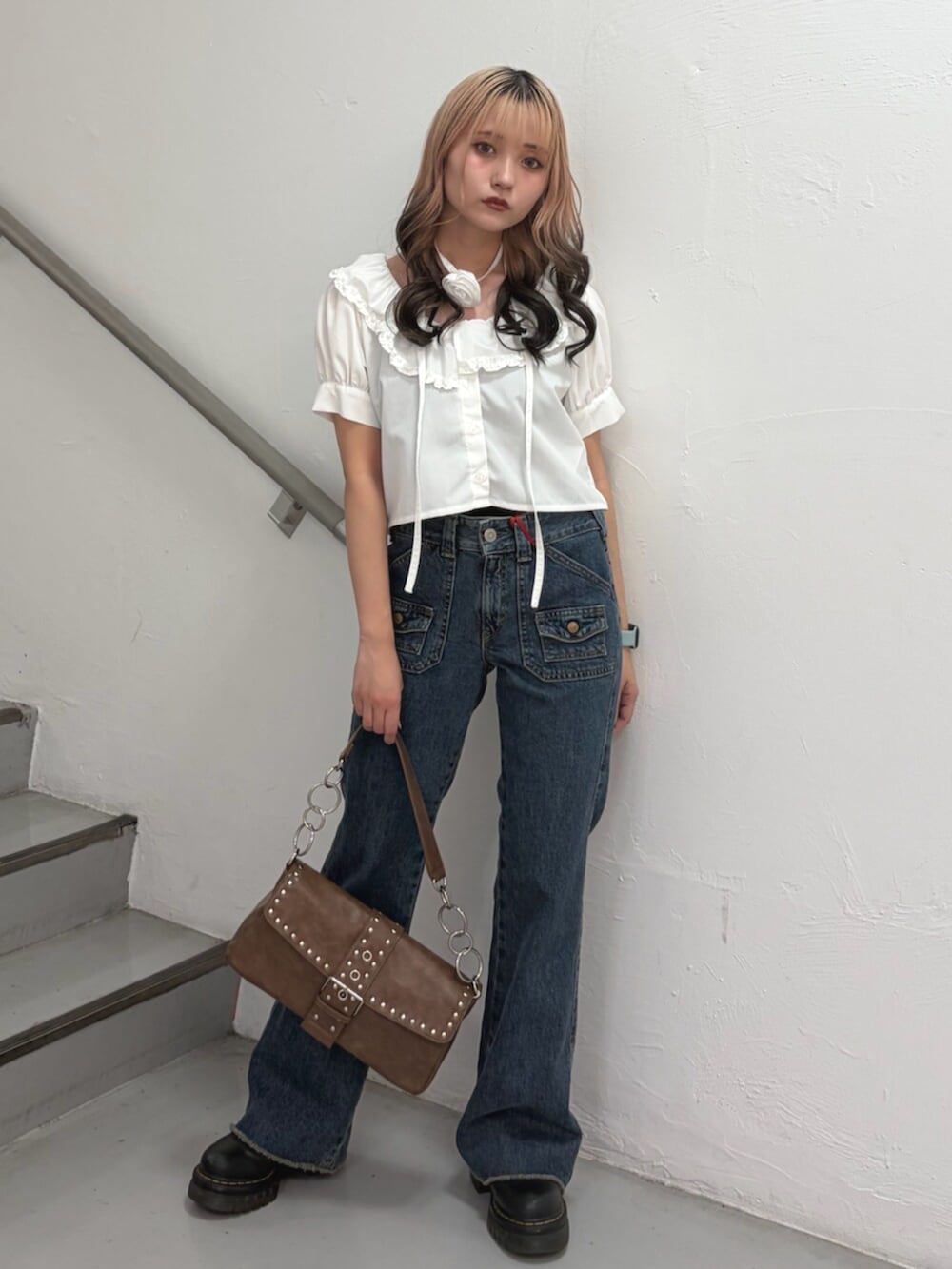 ホワイト系のシャツ/ブラウス、ブルー系のデニムパンツ、ブラウン系のハンドバッグを着用したレディースの春コーディネートの4枚目の写真