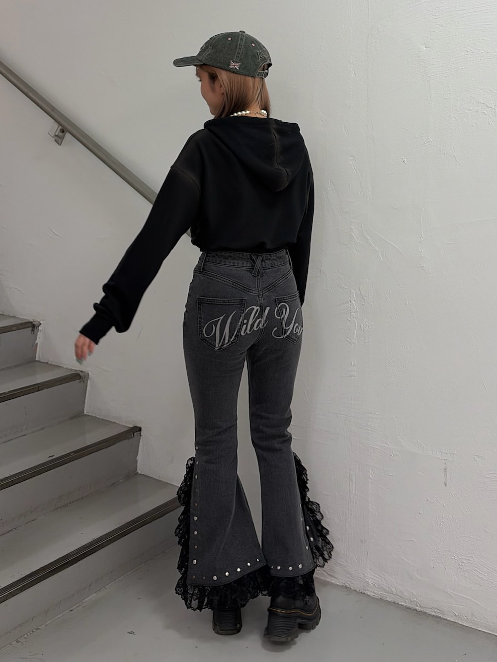 ブラック系のパーカー、ブラック系のデニムパンツ、ベージュ系のキャップを着用したレディースの春コーディネートの3枚目の写真