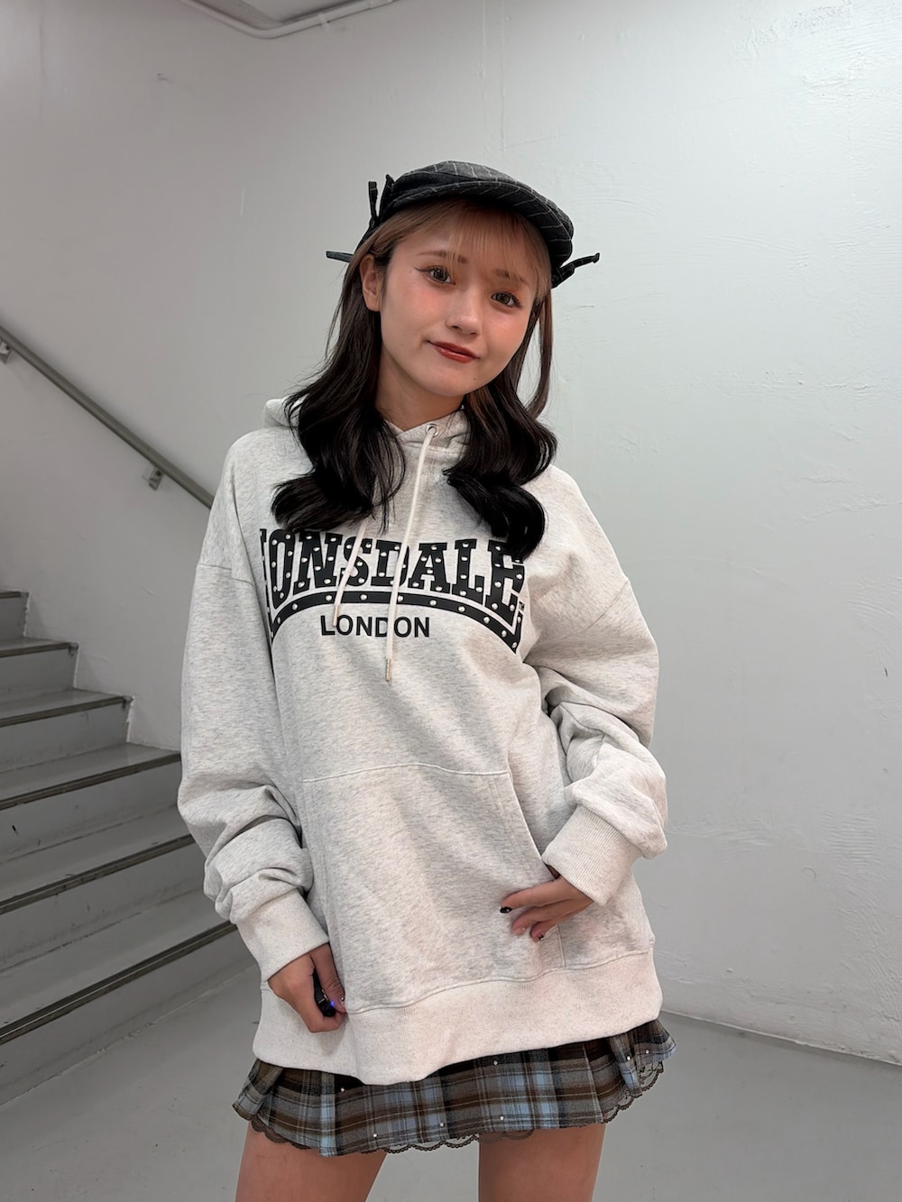 ホワイト系のパーカー、ブラウン系のスカートを着用したレディースの冬コーディネートの4枚目の写真