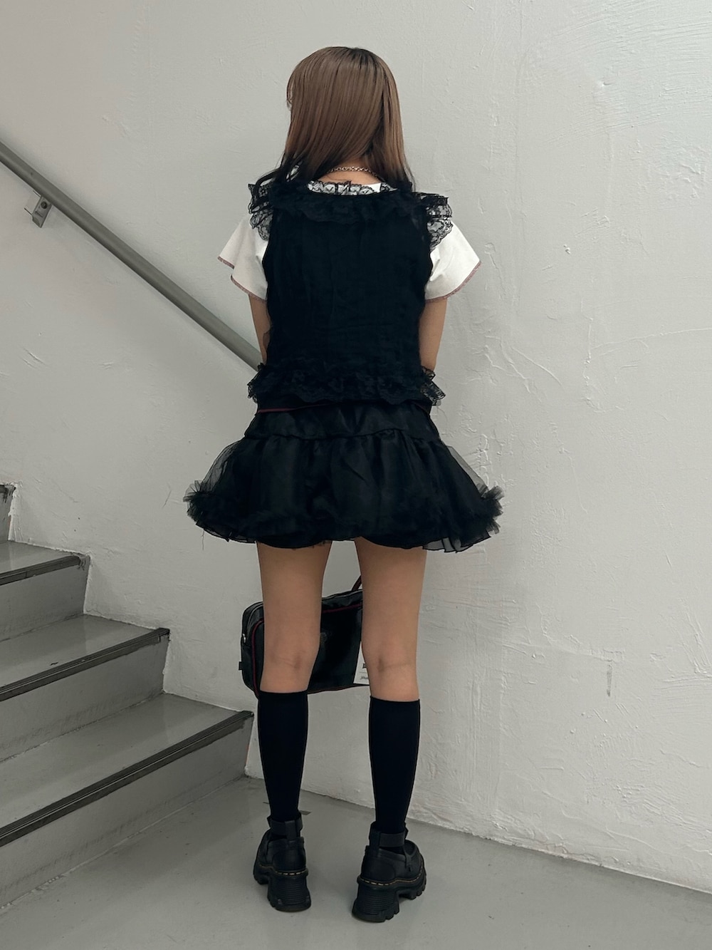 ブラック系のTシャツ/カットソー、ブラック系のスカート、ブラック系のボストンバッグを着用したレディースの夏コーディネートの3枚目の写真