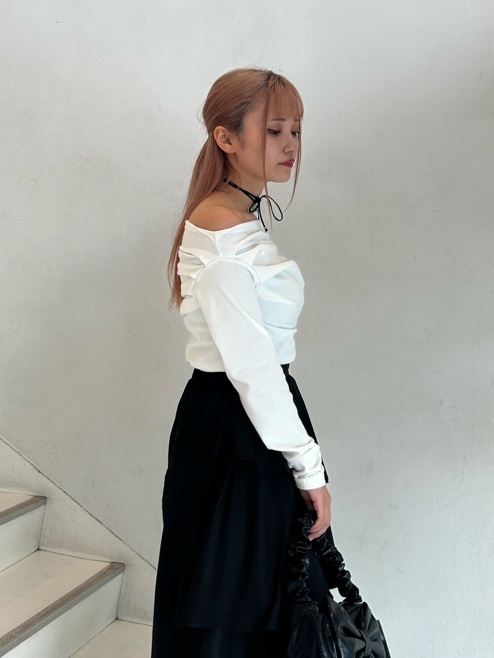 ホワイト系のTシャツ/カットソー、ブラック系のスカート、ブラック系のハンドバッグを着用したレディースの春コーディネートの5枚目の写真