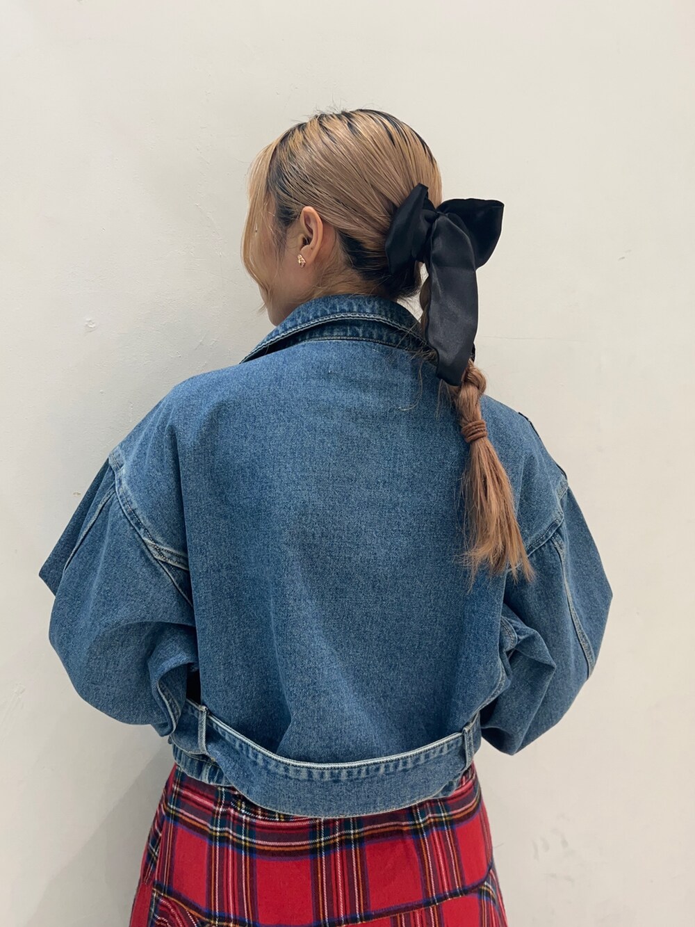 レッド系のスカート、ブラック系のTシャツ/カットソー、ブルー系のライダースジャケットを着用したレディースの秋コーディネートの6枚目の写真