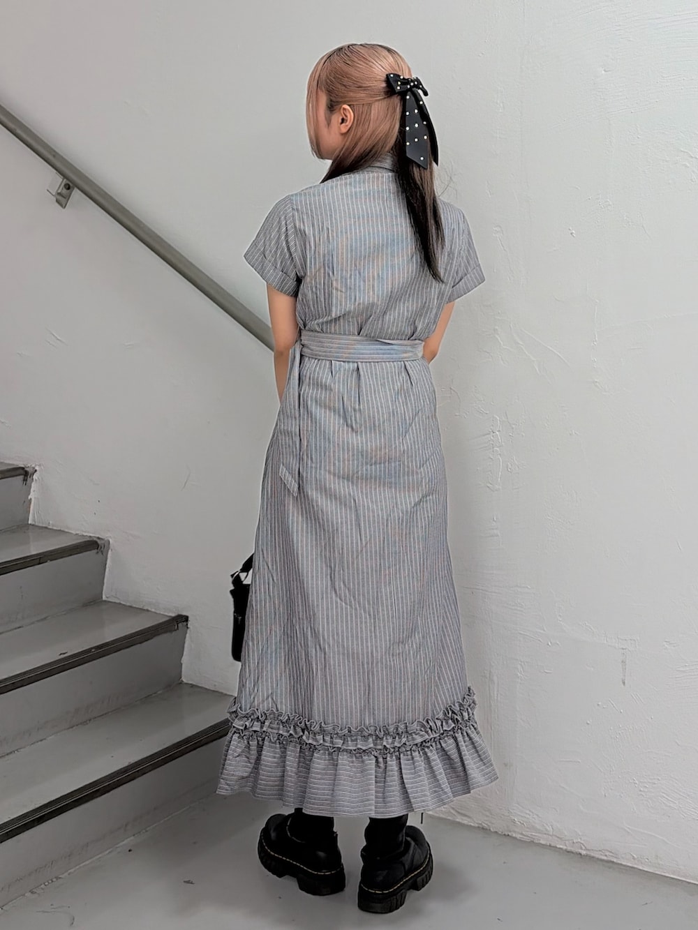 グレー系のワンピース、ブラック系のハンドバッグを着用したレディースの春コーディネートの4枚目の写真