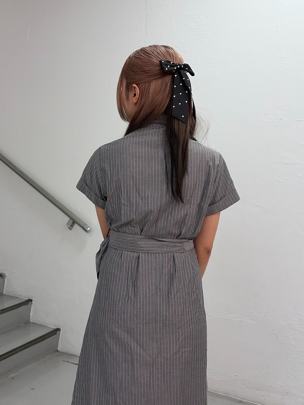 グレー系のワンピース、ブラック系のハンドバッグを着用したレディースの春コーディネートの7枚目の写真