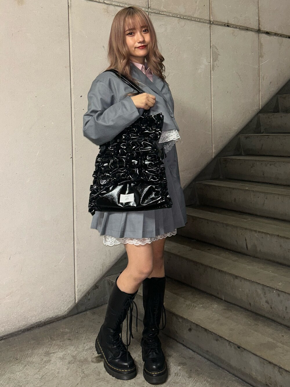 ブラック系のトートバッグ、グレー系のテーラードジャケット、グレー系のスカートを着用したレディースの冬コーディネートの2枚目の写真