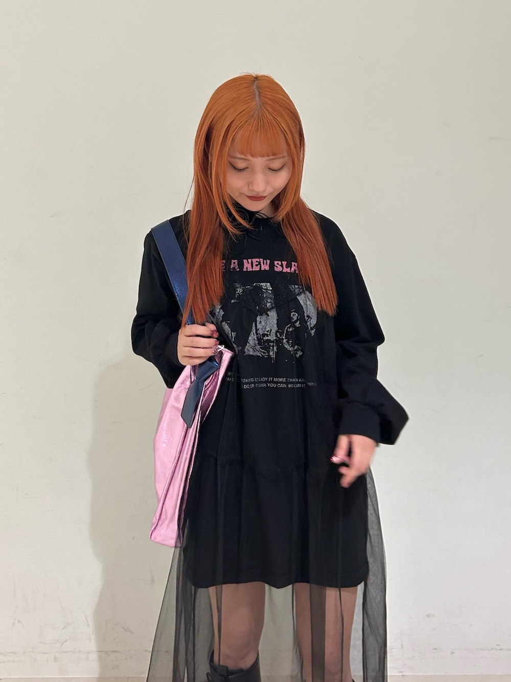 ブラック系のワンピース、ピンク系のトートバッグ、ブラック系のチョーカーを着用したレディースの春コーディネートの4枚目の写真