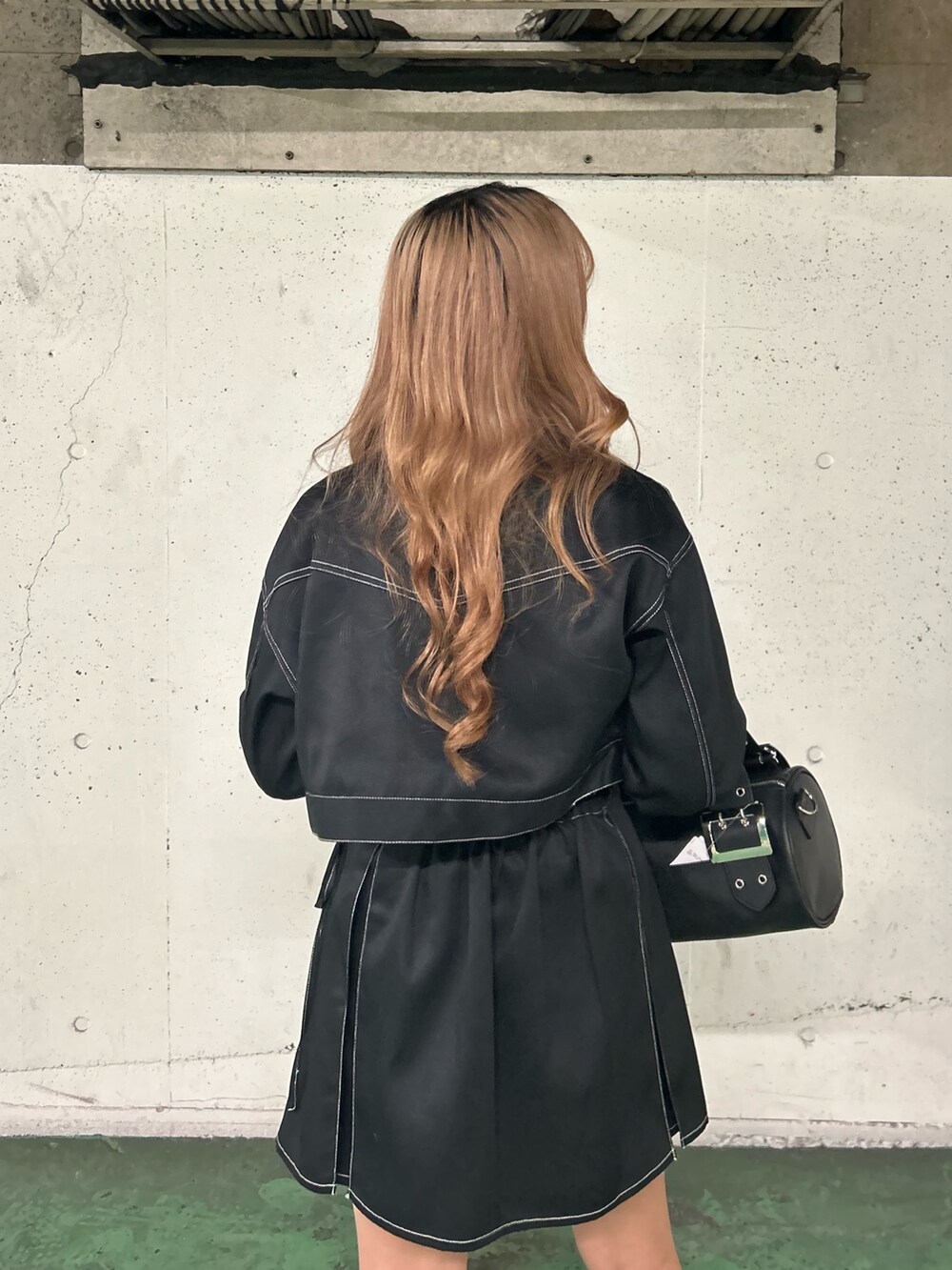 ブラック系のワンピース、レッド系のTシャツ/カットソー、ブラック系のボストンバッグを着用したレディースの春コーディネートの6枚目の写真