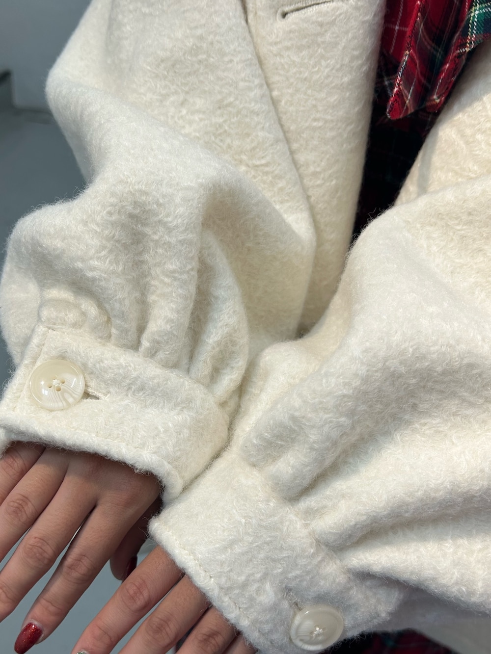 レッド系のワンピース、ホワイト系のその他アウター、ブラック系のバレッタ/ヘアクリップを着用したレディースの冬コーディネートの10枚目の写真