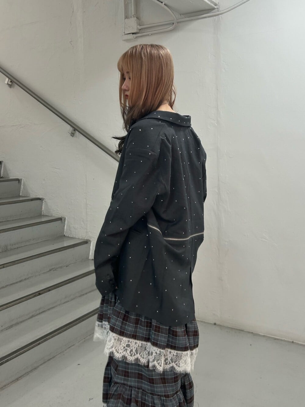 グレー系のテーラードジャケット、ブラック系のスニーカー、ブラウン系のワンピースを着用したレディースの秋コーディネートの5枚目の写真