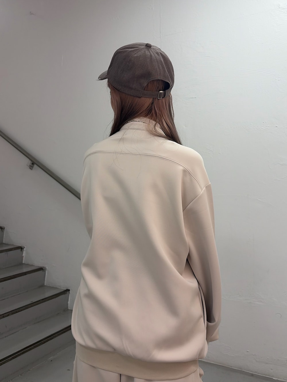 ホワイト系のジャージ、ホワイト系のその他パンツ、ブラウン系のキャップを着用したレディースの冬コーディネートの6枚目の写真