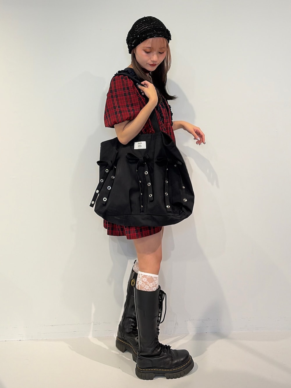 レッド系のワンピース、ブラック系のトートバッグを着用したレディースの冬コーディネートの2枚目の写真