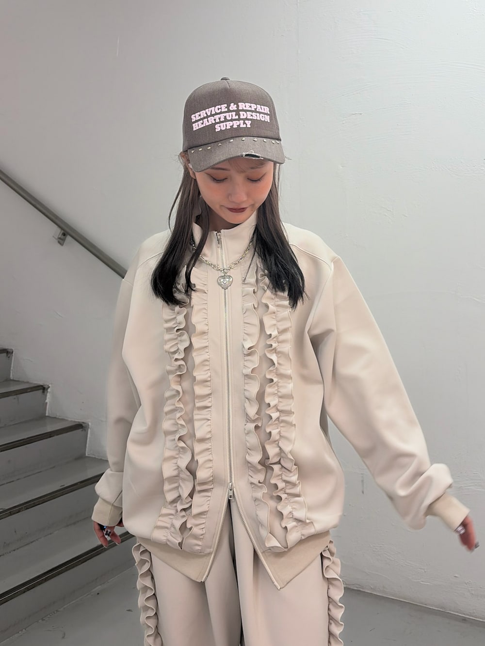 ホワイト系のジャージ、ホワイト系のその他パンツ、ブラウン系のキャップを着用したレディースの冬コーディネートの4枚目の写真