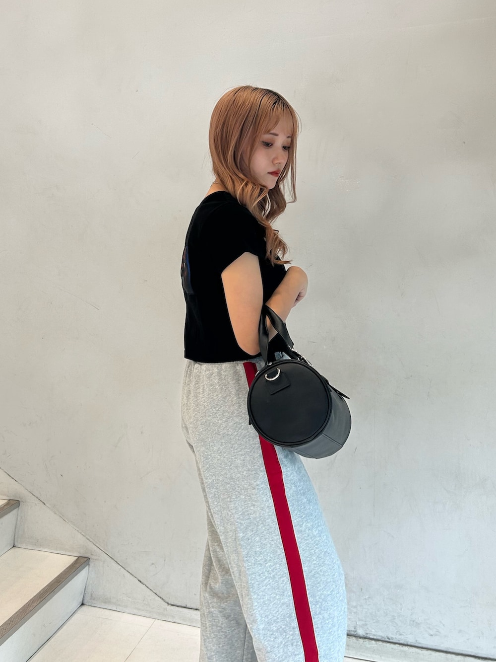 ブラック系のTシャツ/カットソー、グレー系のスウェットパンツ、ブラック系のボストンバッグを着用したレディースの春コーディネートの5枚目の写真