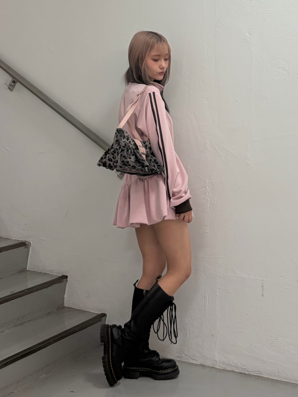 ピンク系のジャージ、ピンク系のスカート、ブラック系のハンドバッグを着用したレディースの冬コーディネートの5枚目の写真