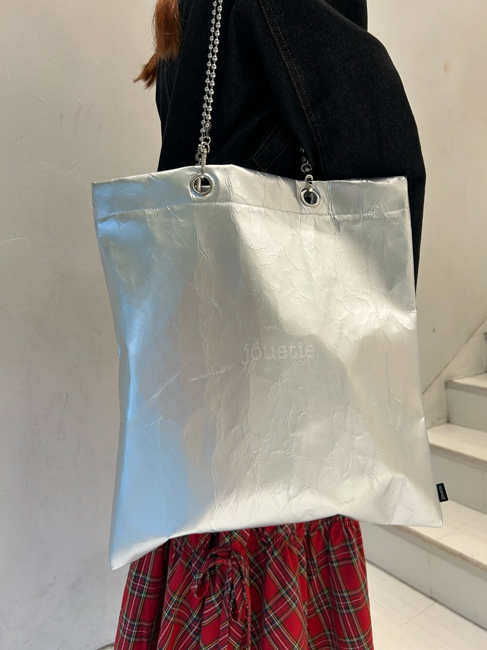 ブラック系のニット/セーター、ブラック系のワンピース、レッド系のスカートを着用したレディースの春コーディネートの7枚目の写真