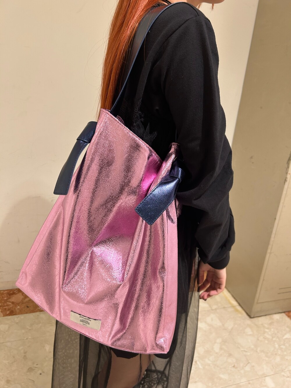 ブラック系のワンピース、ピンク系のトートバッグ、ブラック系のチョーカーを着用したレディースの春コーディネートの8枚目の写真