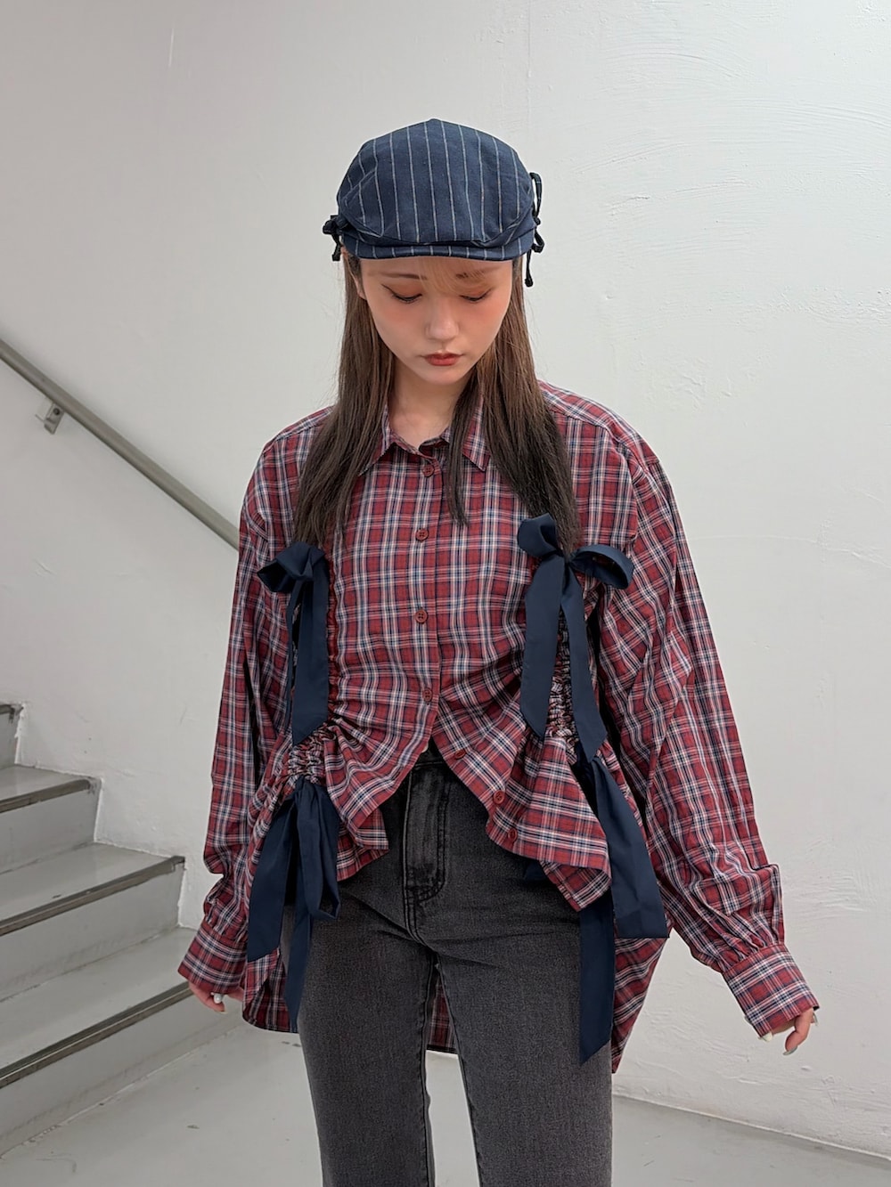 レッド系のシャツ/ブラウス、ブラック系のデニムパンツ、ブルー系のハンチング/ベレー帽を着用したレディースの春コーディネートの5枚目の写真