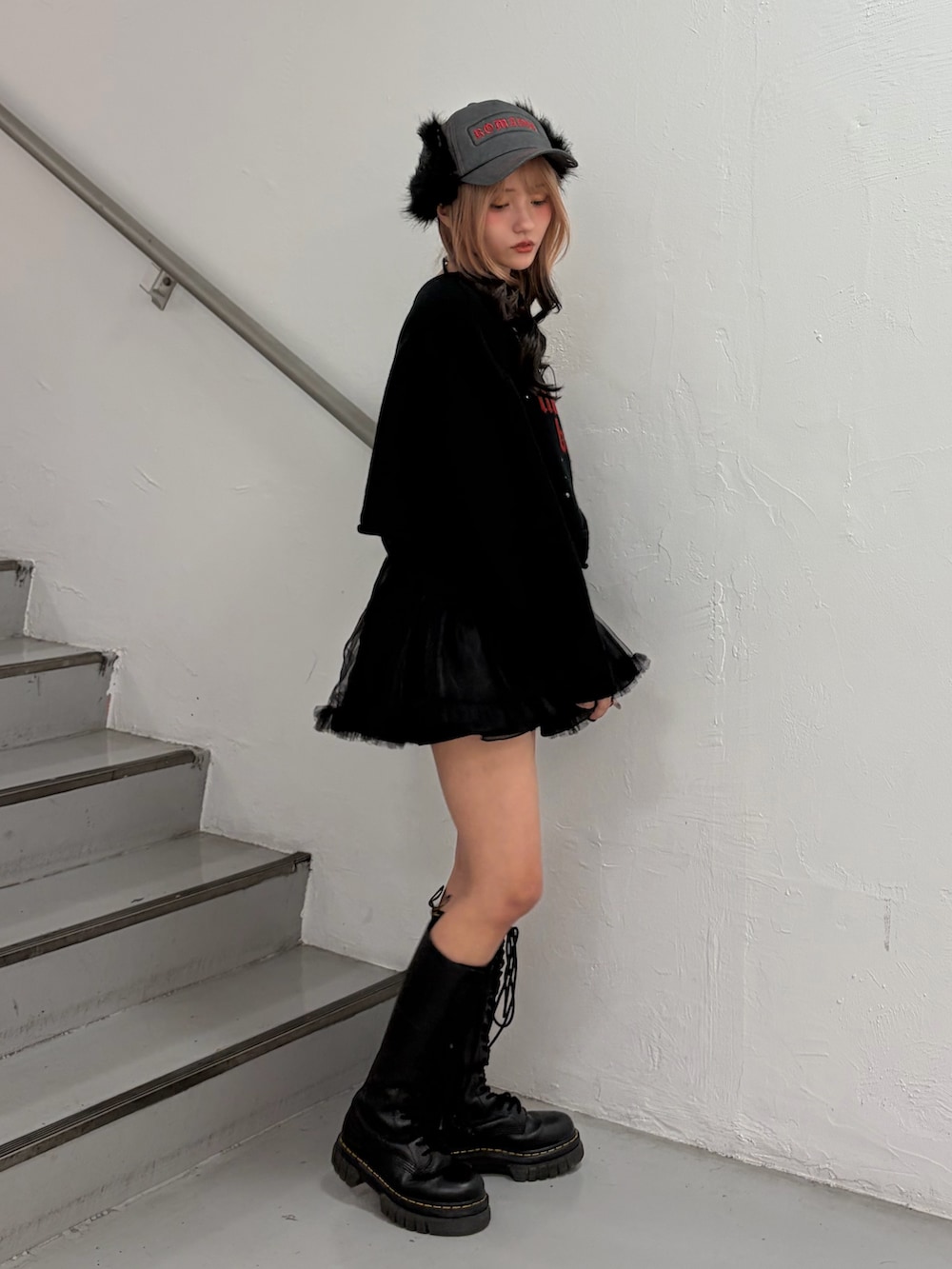 ブラック系のニット/セーター、ブラック系のスカート、ブラック系のキャップを着用したレディースの秋コーディネートの3枚目の写真