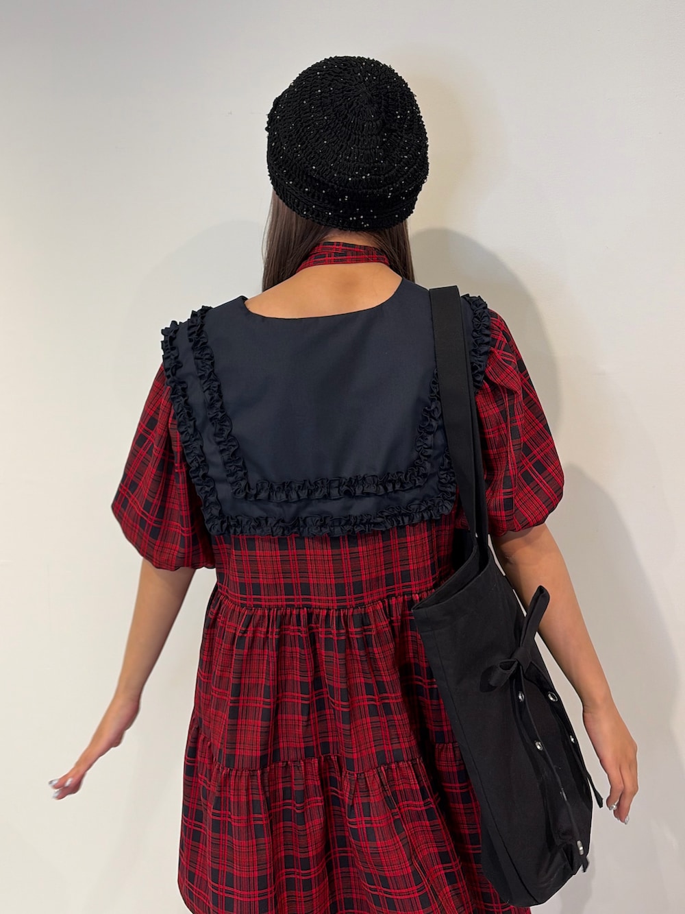 レッド系のワンピース、ブラック系のトートバッグを着用したレディースの冬コーディネートの7枚目の写真