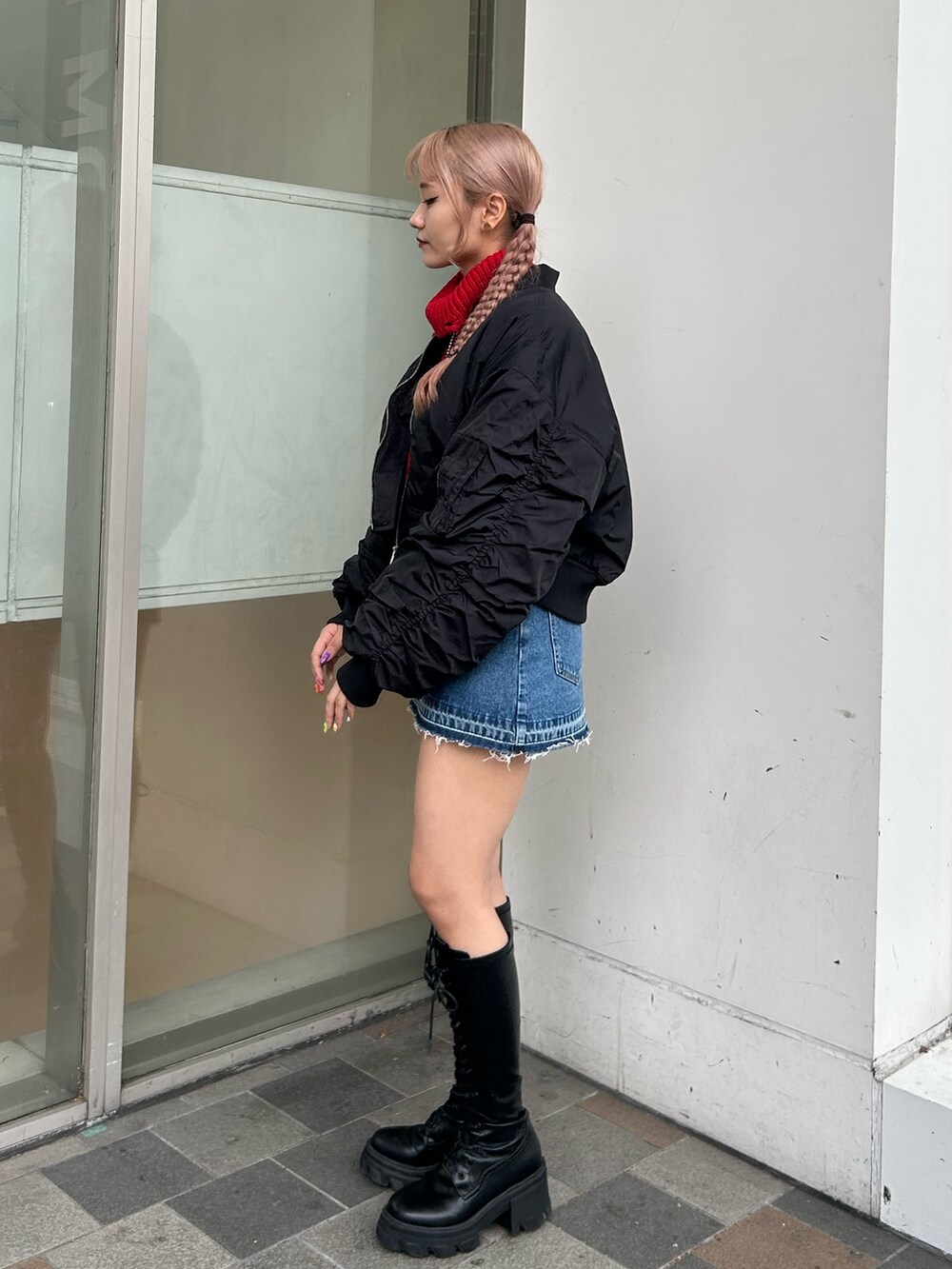 ブルー系のデニムパンツ、ブラック系のMA-1、レッド系のニット/セーターを着用したレディースの秋コーディネートの2枚目の写真