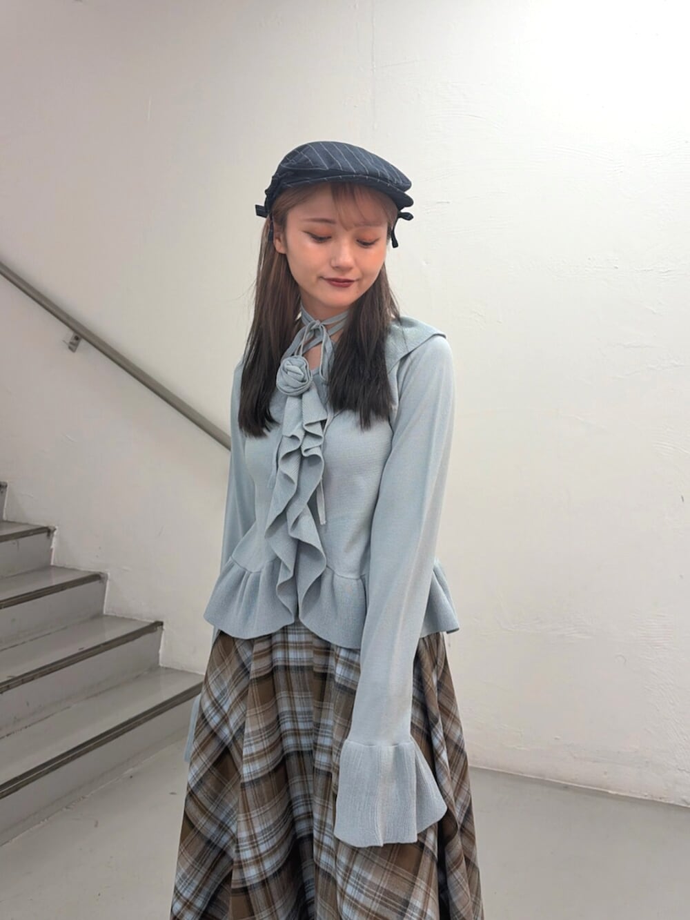 ブラウン系のスカート、ブルー系のニット/セーター、ブルー系のハンチング/ベレー帽を着用したレディースの冬コーディネートの5枚目の写真