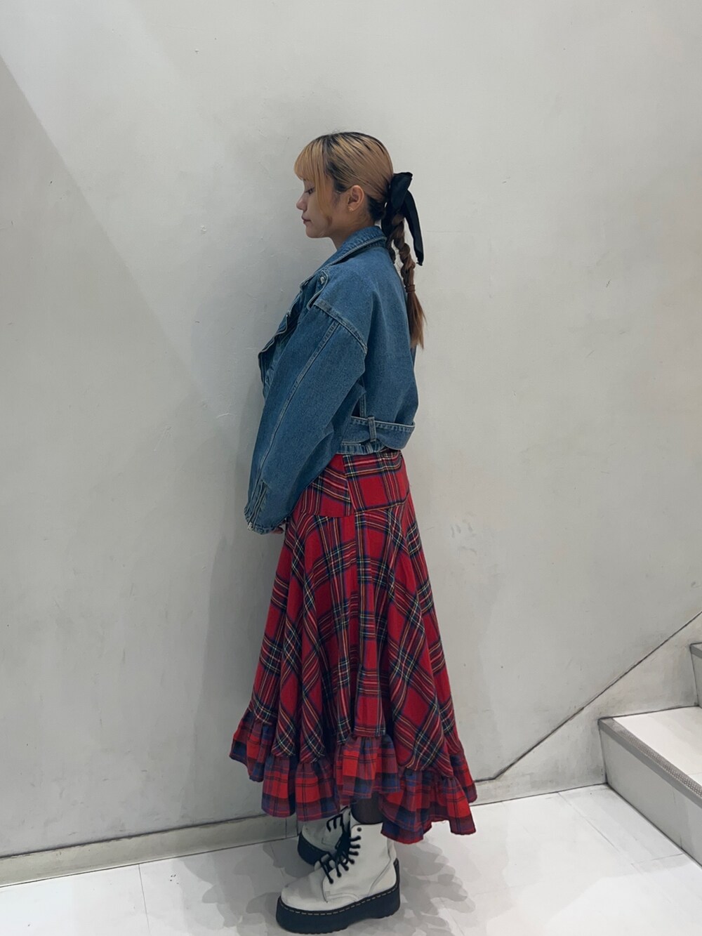 レッド系のスカート、ブラック系のTシャツ/カットソー、ブルー系のライダースジャケットを着用したレディースの秋コーディネートの2枚目の写真